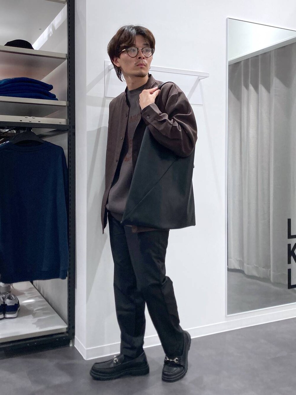 ブラック系のその他パンツ、ブラック系のトートバッグ、ブラック系のローファーを着用したメンズの秋コーディネートの3枚目の写真