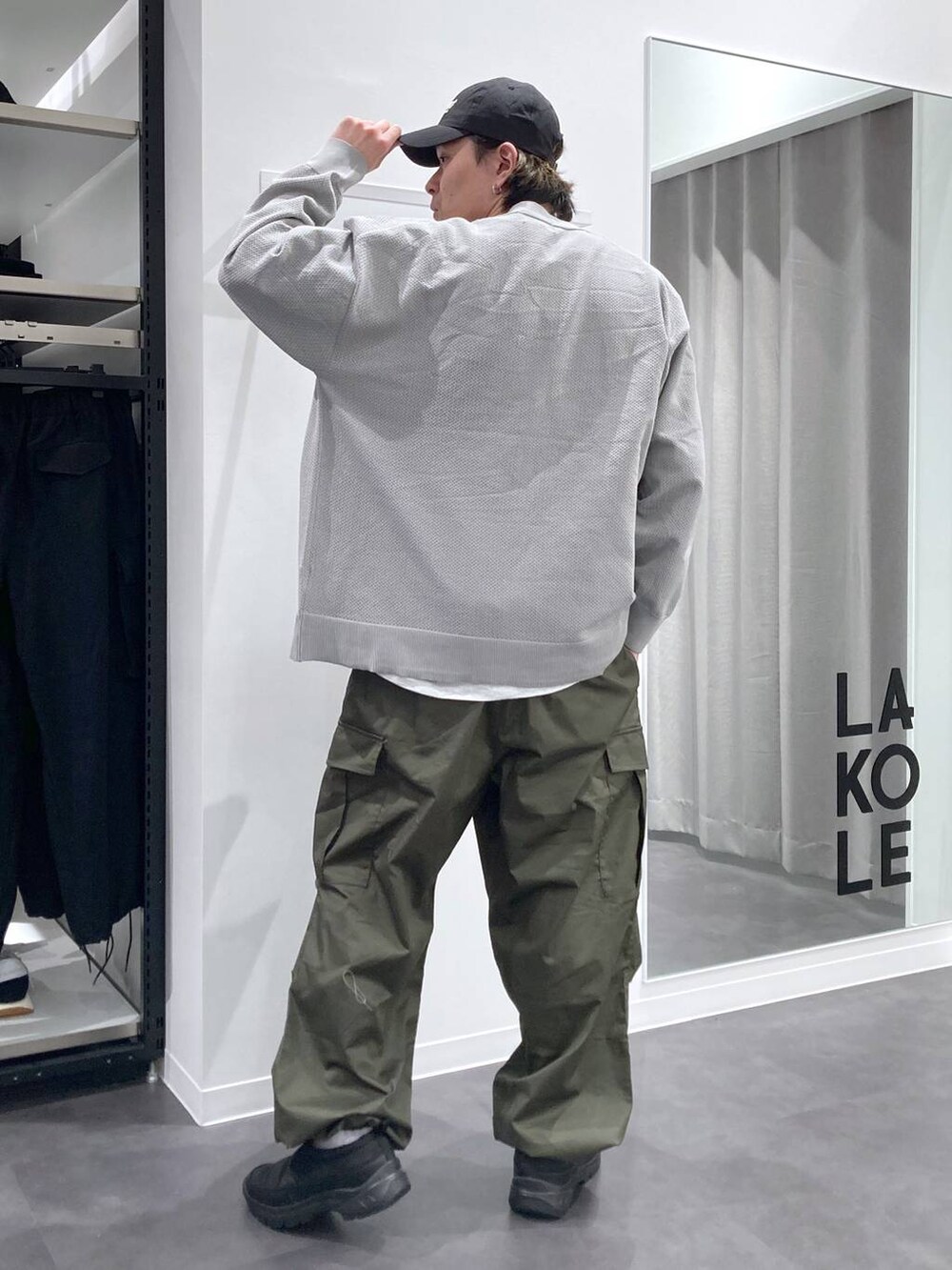 グレー系のTシャツ/カットソー、ブラック系のスリッポン、グリーン系のカーゴパンツを着用したメンズの春コーディネートの2枚目の写真