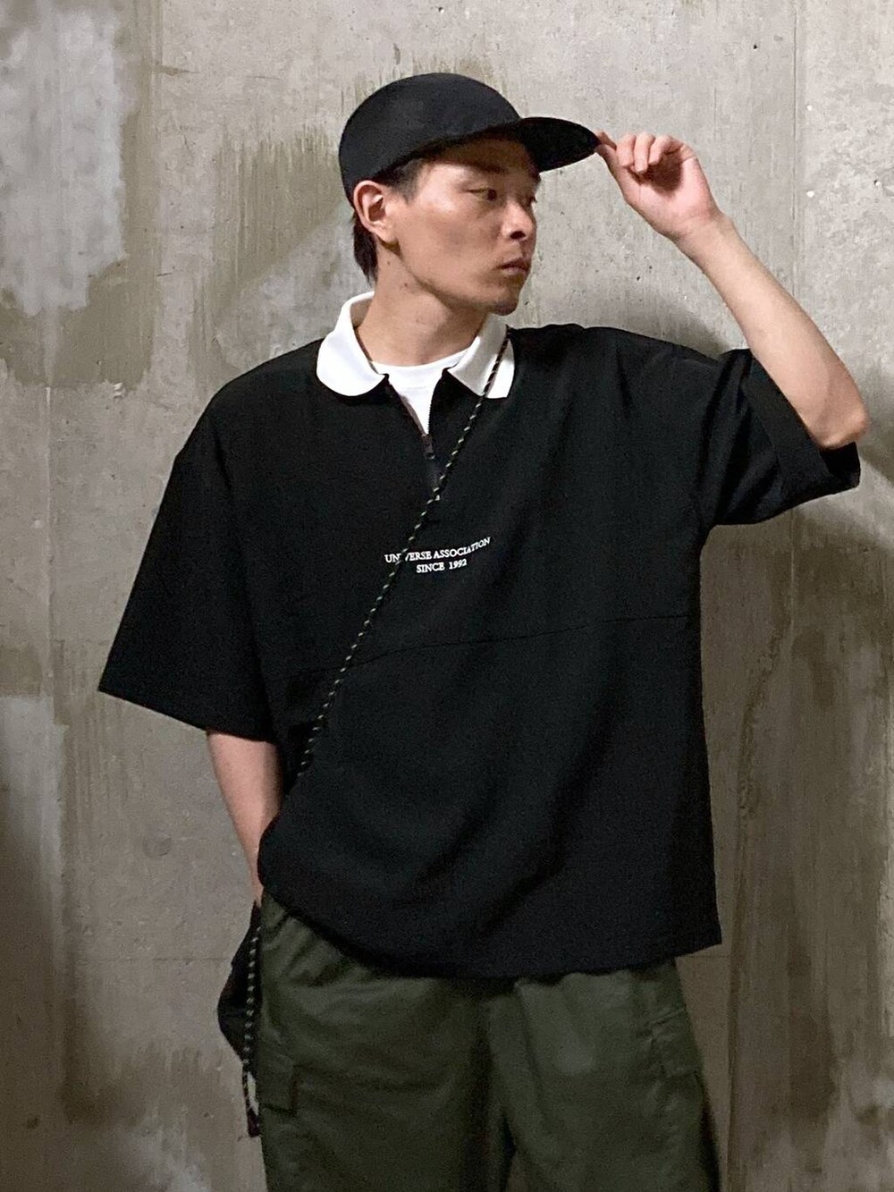 ホワイト系のTシャツ/カットソー、グリーン系のカーゴパンツ、ブラック系のショルダーバッグを着用したメンズの夏コーディネートの7枚目の写真