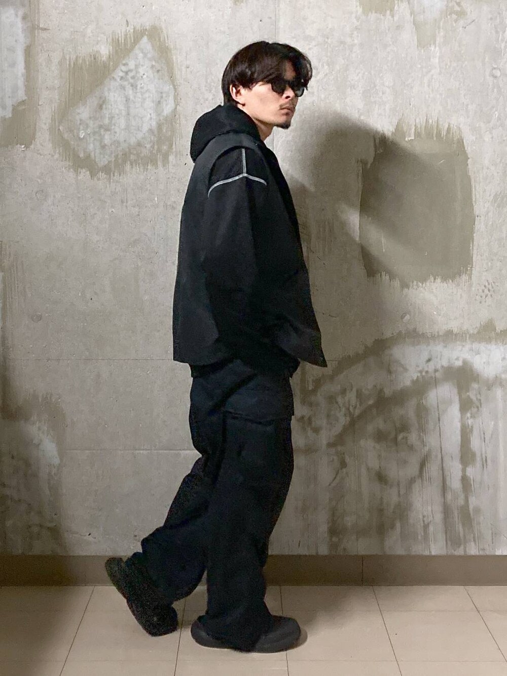 ブラック系のTシャツ/カットソー、ブラック系のカーゴパンツ、ブラック系のブルゾンを着用したメンズの秋コーディネートの4枚目の写真