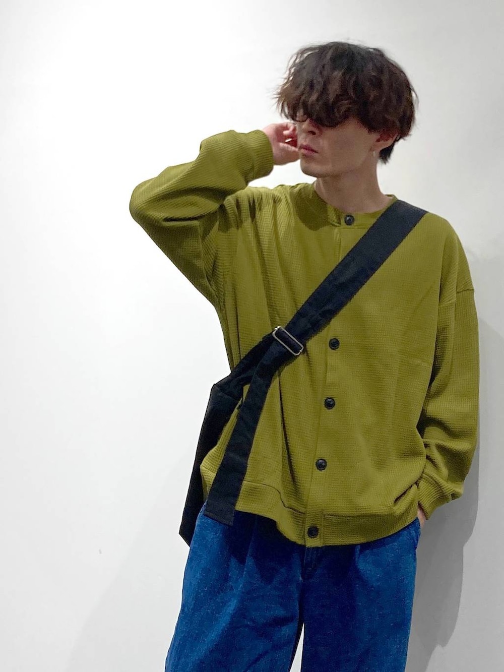 ホワイト系のスニーカー、イエロー系のTシャツ/カットソー、ブルー系のデニムパンツを着用したメンズの秋コーディネートの5枚目の写真