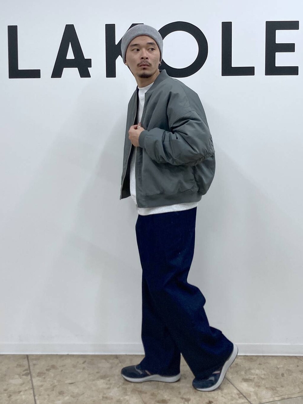 ブルー系のスニーカー、グリーン系のブルゾン、ブルー系のデニムパンツを着用したメンズの冬コーディネートの3枚目の写真