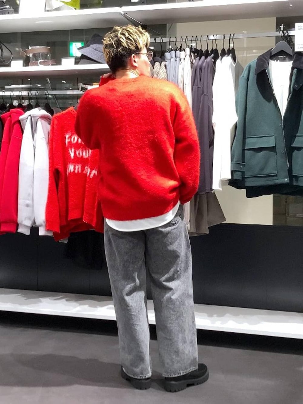 レッド系のニット/セーター、ブラック系のドレスシューズ、グレー系のデニムパンツを着用したメンズの冬コーディネートの2枚目の写真