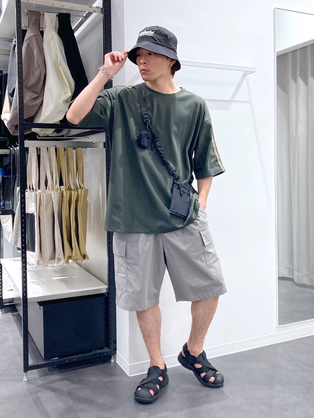 ブラック系のショルダーバッグ、ブラック系のサンダル、グリーン系のTシャツ/カットソーを着用したメンズの夏コーディネートの5枚目の写真