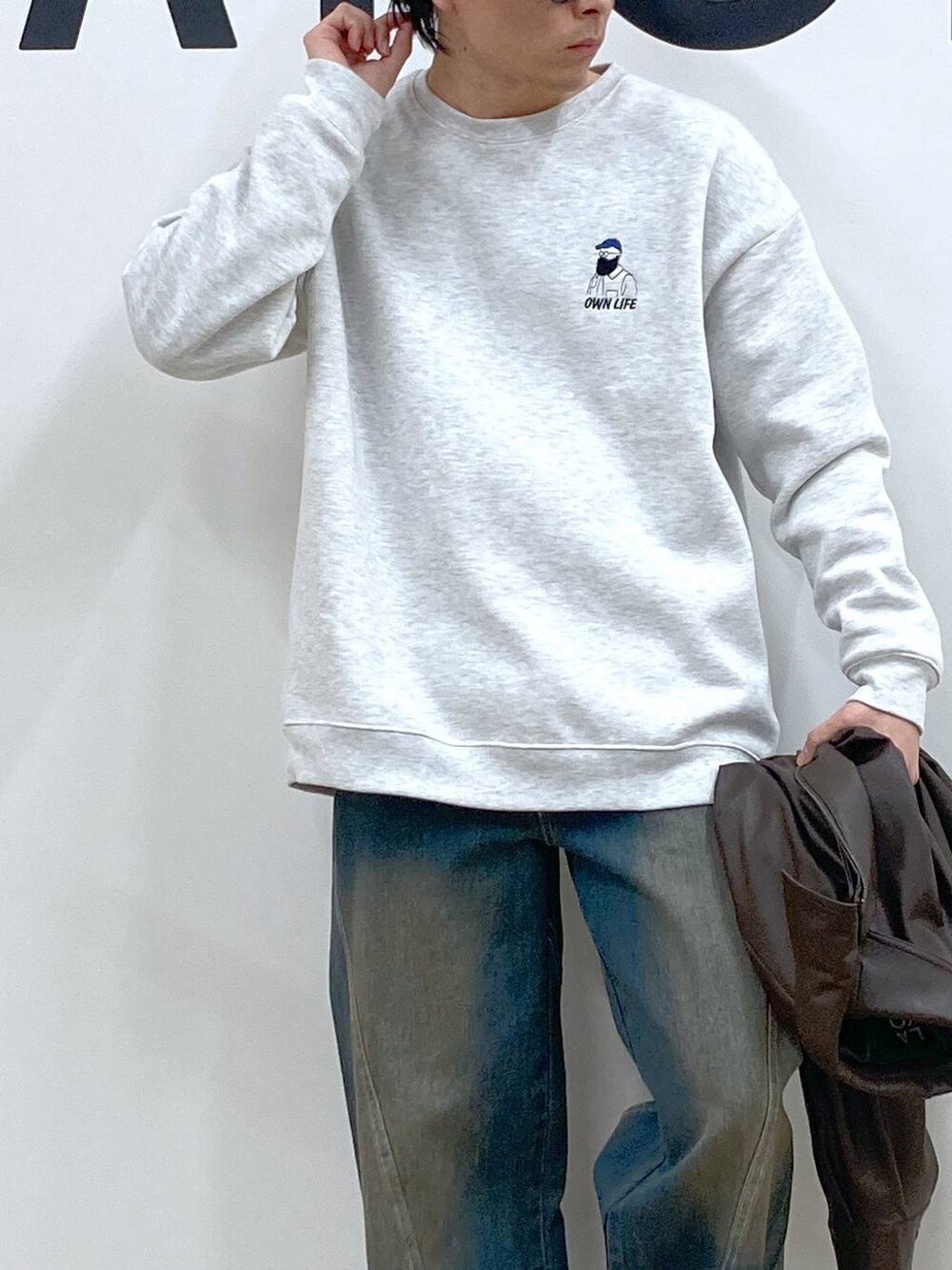 ブルー系のデニムパンツ、グレー系のスウェット、ブラック系のローファーを着用したメンズの冬コーディネートの5枚目の写真