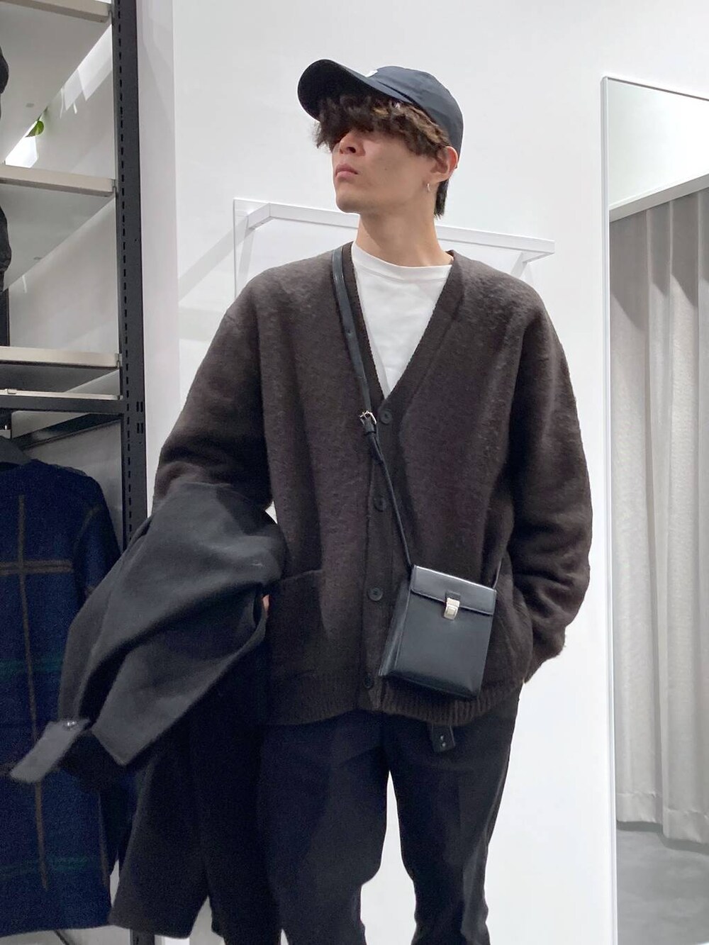 ブラック系のトレンチコート、グレー系のTシャツ/カットソー、ホワイト系のスウェットを着用したメンズの冬コーディネートの4枚目の写真