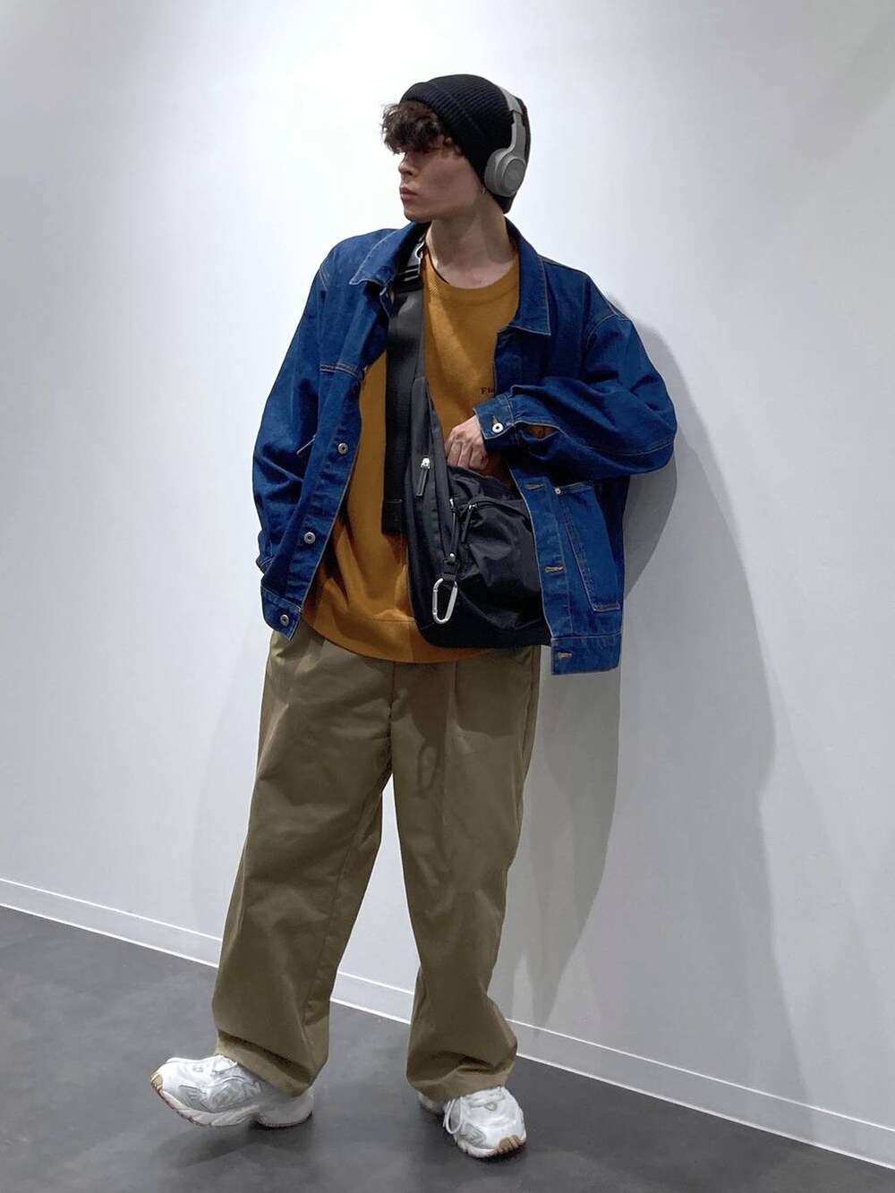 ブラック系のボディバッグ/ウエストポーチ、ホワイト系のスニーカー、ブルー系のデニムジャケットを着用したメンズの秋コーディネートの6枚目の写真