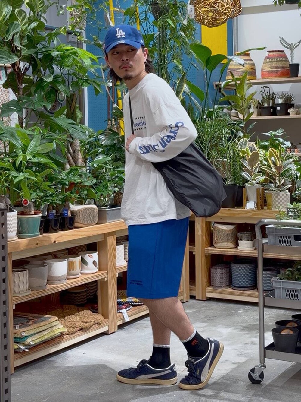 ブラック系のエコバッグ/サブバッグ、ホワイト系のTシャツ/カットソー、ブルー系のその他パンツを着用したメンズの春コーディネートの3枚目の写真