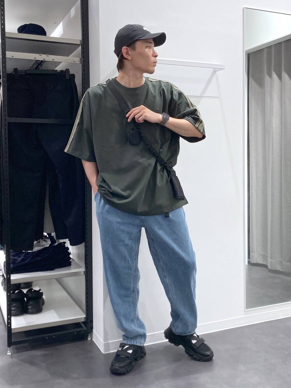 ブラック系のスニーカー、ブラック系のショルダーバッグ、ブルー系のデニムパンツを着用したメンズの夏コーディネートの5枚目の写真