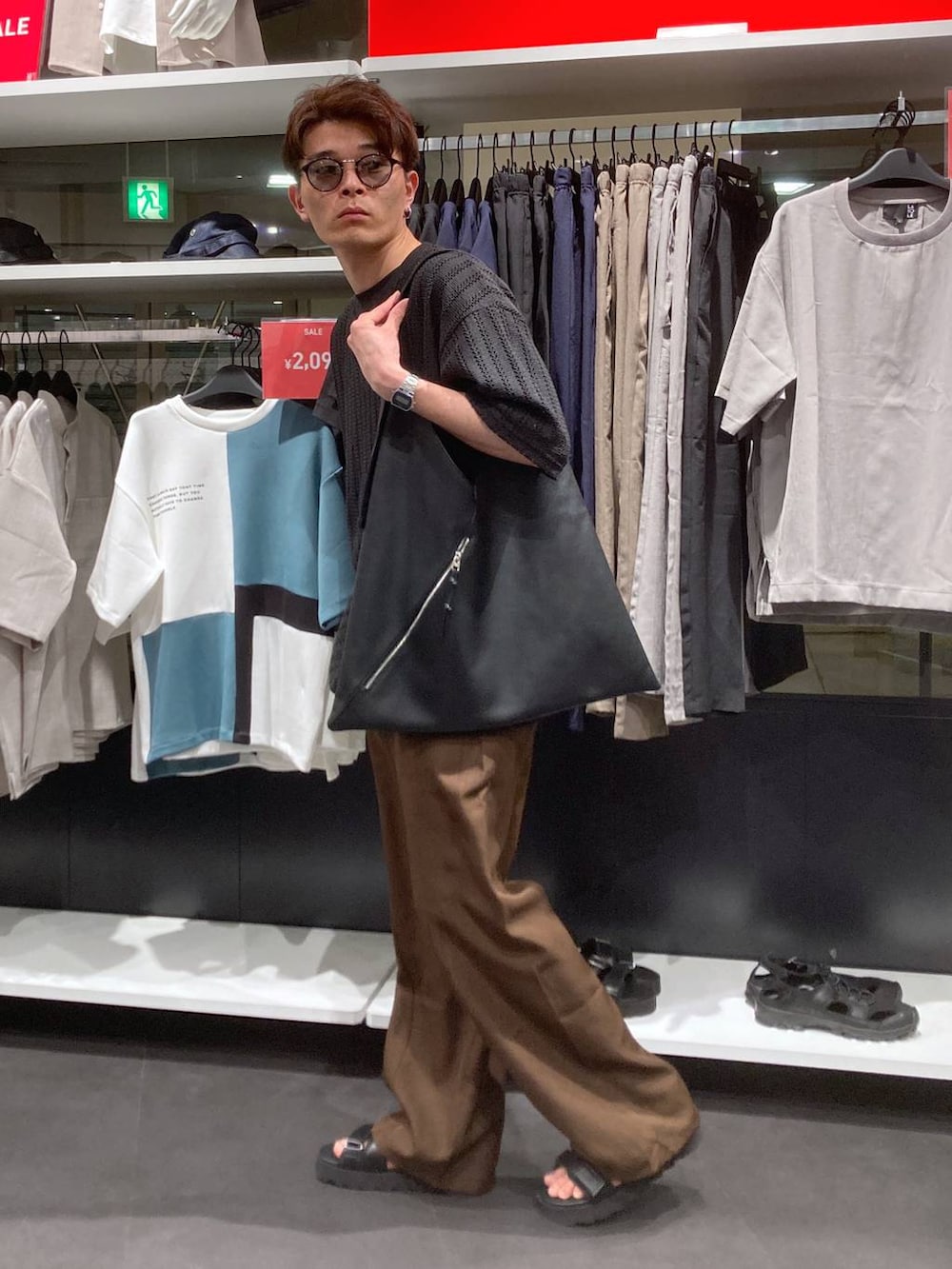 ブラック系のサンダル、ブラック系のTシャツ/カットソー、ブラック系のトートバッグを着用したメンズの夏コーディネートの3枚目の写真