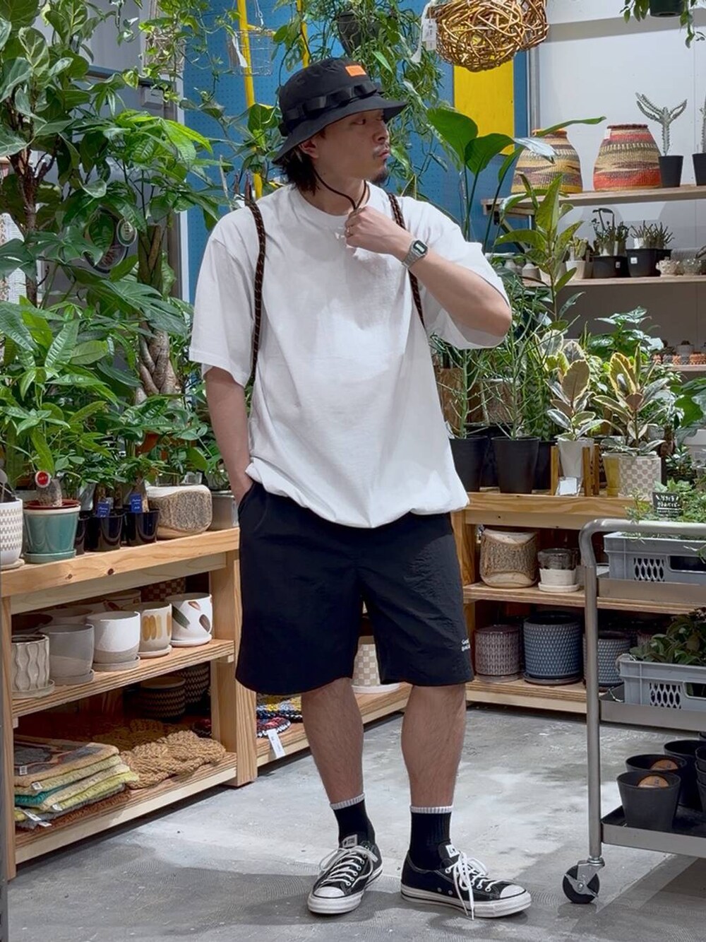 ブラック系のスニーカー、オレンジ系のバックパック/リュック、ホワイト系のTシャツ/カットソーを着用したメンズの春コーディネートの7枚目の写真