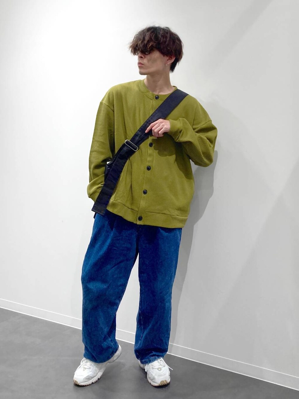 ホワイト系のスニーカー、イエロー系のTシャツ/カットソー、ブルー系のデニムパンツを着用したメンズの秋コーディネートの6枚目の写真