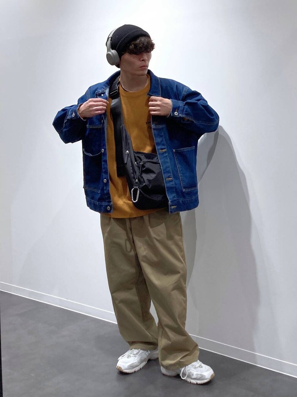 ブラック系のボディバッグ/ウエストポーチ、ホワイト系のスニーカー、ブルー系のデニムジャケットを着用したメンズの秋コーディネートの8枚目の写真