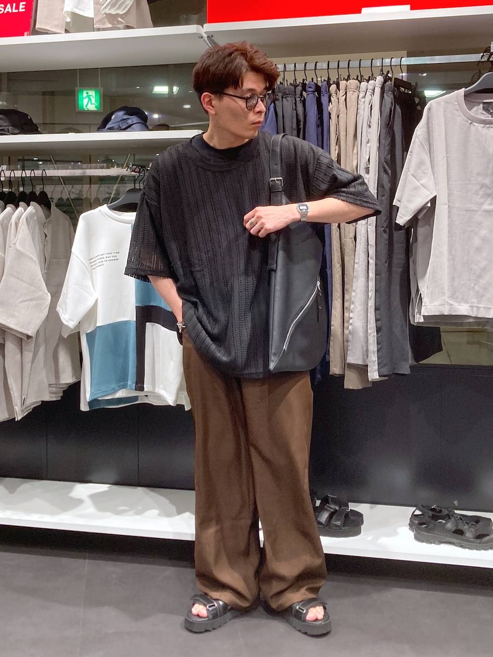 ブラック系のサンダル、ブラック系のTシャツ/カットソー、ブラック系のトートバッグを着用したメンズの夏コーディネートの6枚目の写真