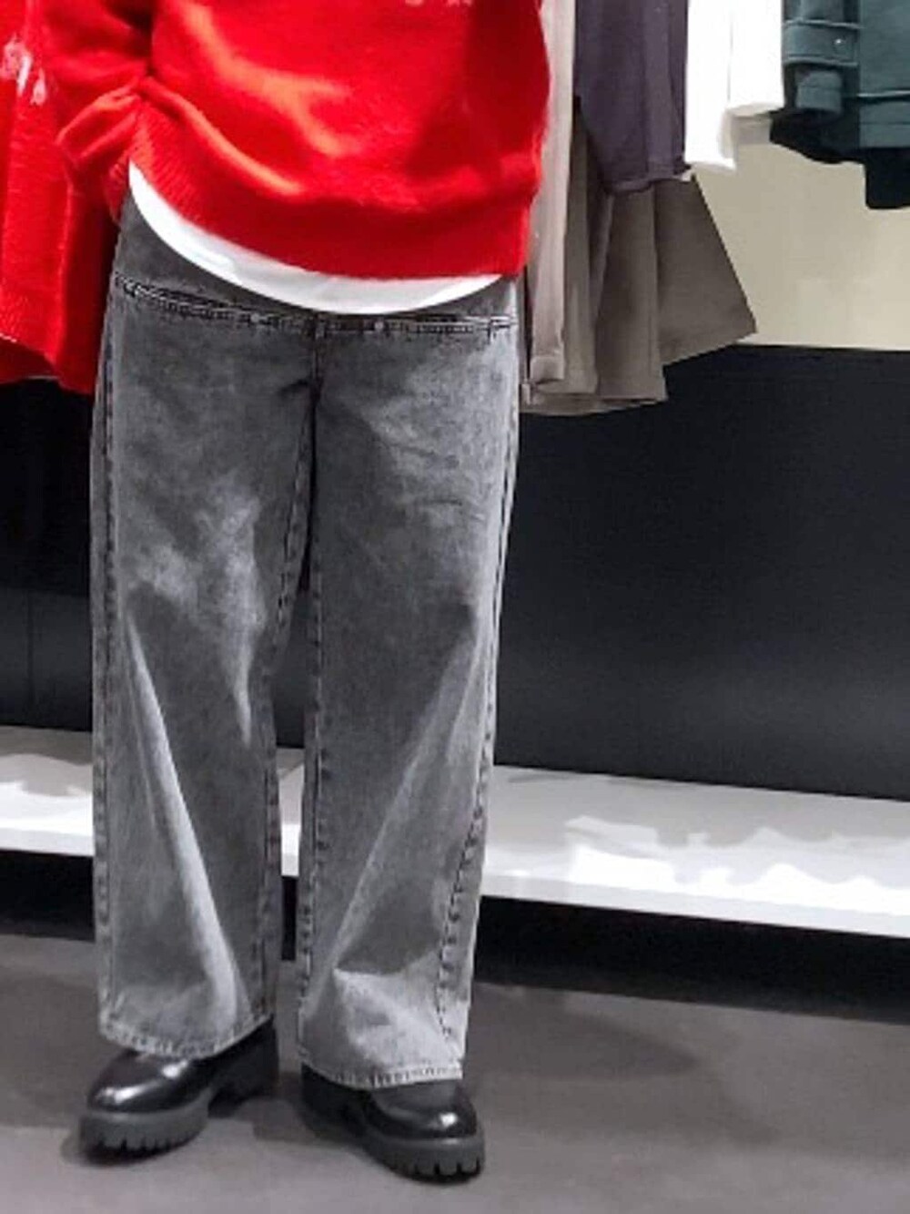 レッド系のニット/セーター、ブラック系のドレスシューズ、グレー系のデニムパンツを着用したメンズの冬コーディネートの7枚目の写真