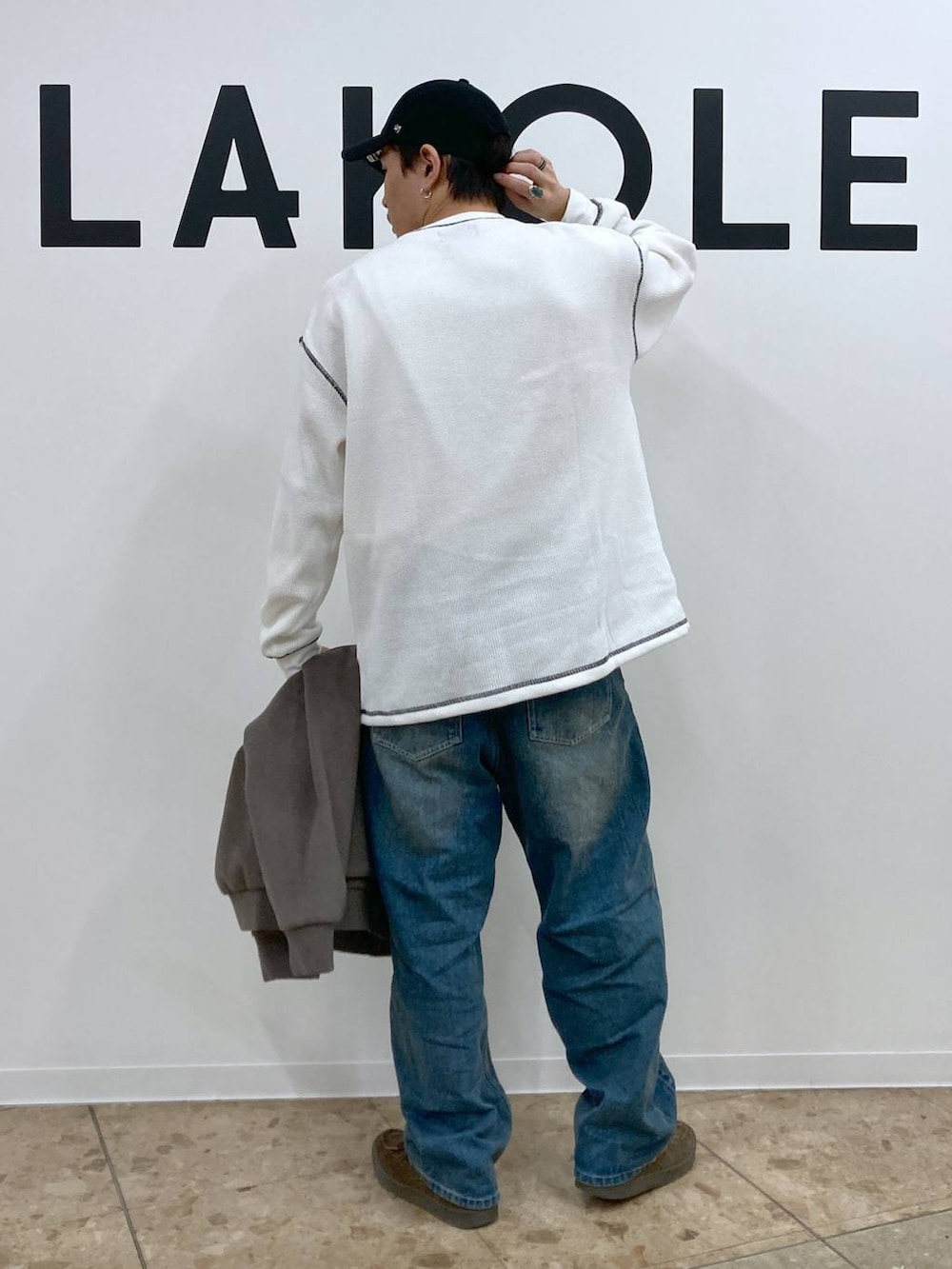 ブラウン系のブルゾン、ブルー系のデニムパンツ、ホワイト系のTシャツ/カットソーを着用したメンズの秋コーディネートの6枚目の写真