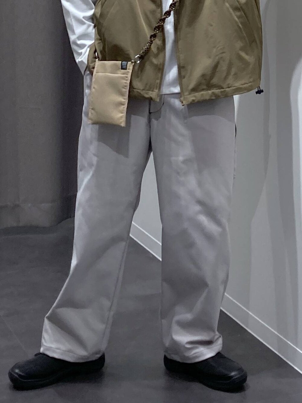 ベージュ系のベスト、グレー系のその他パンツ、ブラック系のスリッポンを着用したメンズの冬コーディネートの7枚目の写真