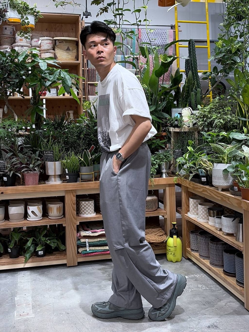 グレー系のスラックス、ホワイト系のTシャツ/カットソーを着用したメンズの夏コーディネートの3枚目の写真