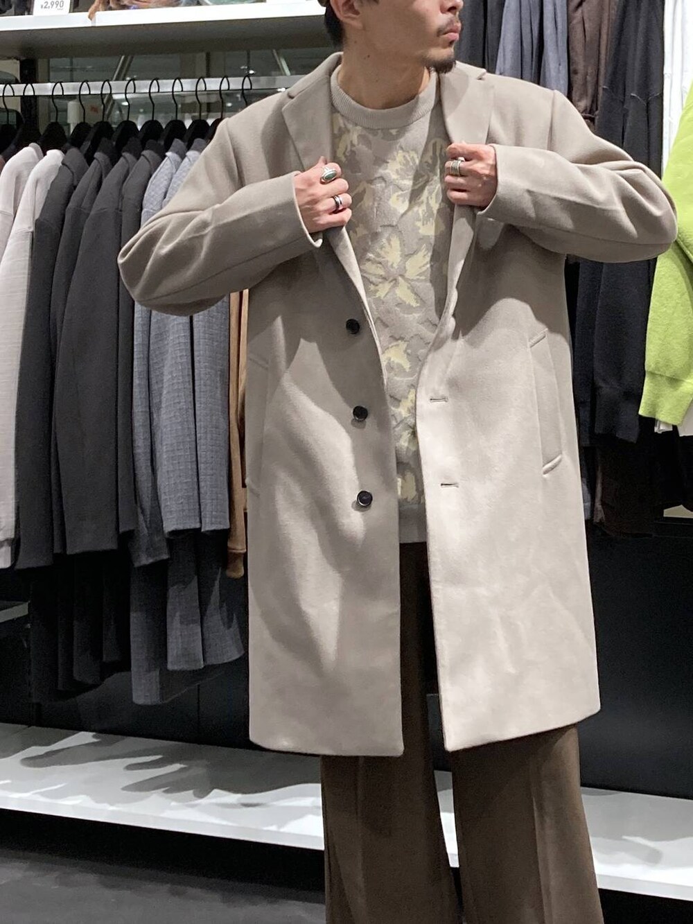 ホワイト系のチェスターコート、ベージュ系のニット/セーター、ブラウン系のその他パンツを着用したメンズの冬コーディネートの8枚目の写真