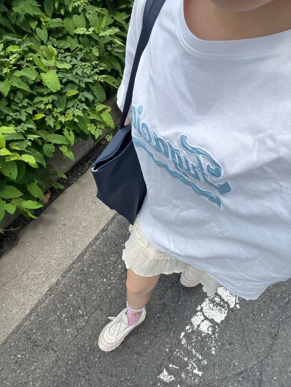 ブルー系のトートバッグ、ホワイト系のTシャツ/カットソー、ホワイト系のスカートを着用したレディースの夏コーディネートの2枚目の写真