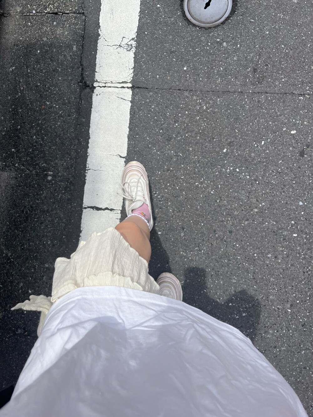 ブルー系のトートバッグ、ホワイト系のTシャツ/カットソー、ホワイト系のスカートを着用したレディースの夏コーディネートの3枚目の写真