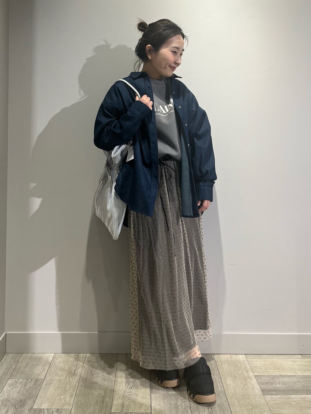 ブルー系のシャツ/ブラウス、ブラック系のスカート、ブラック系のスニーカーを着用したレディースの冬コーディネートの5枚目の写真