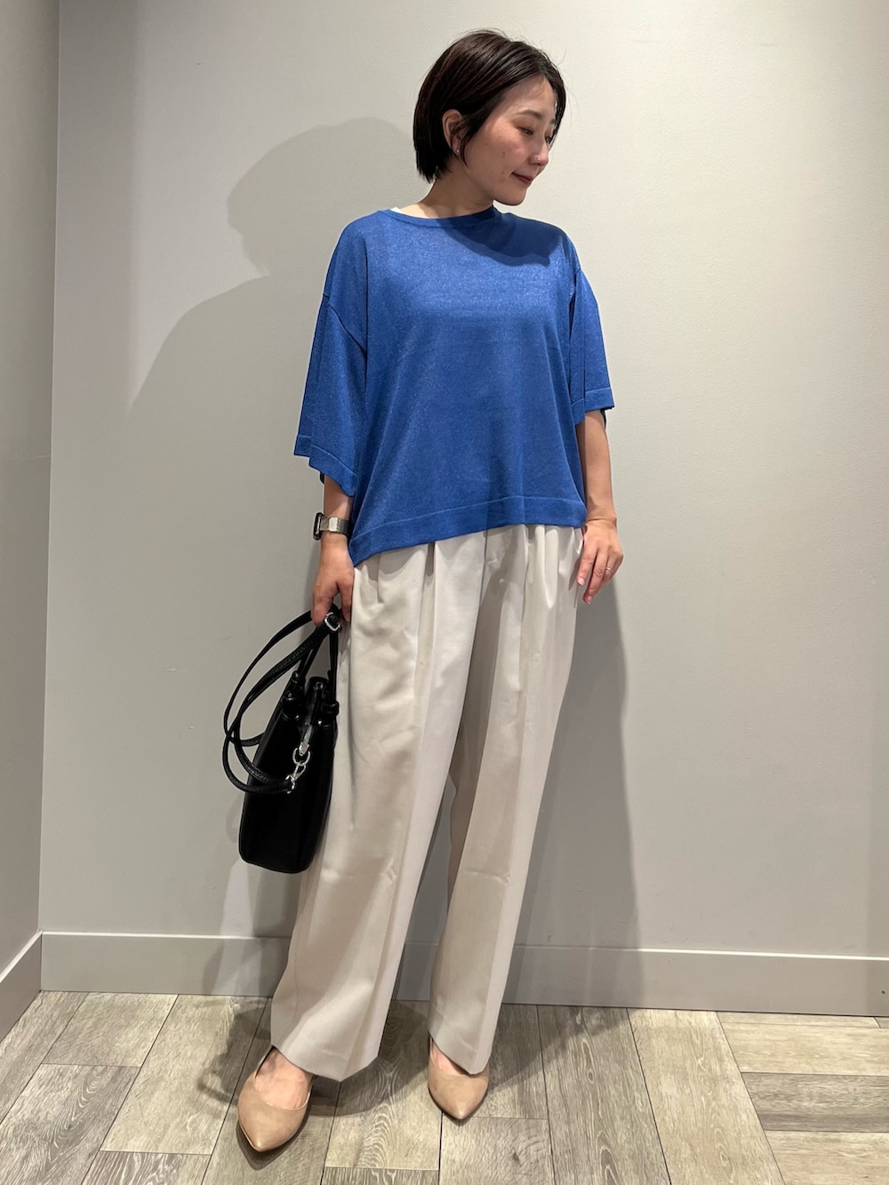 ブルー系のニット/セーター、ベージュ系のその他パンツを着用したレディースの夏コーディネートの2枚目の写真