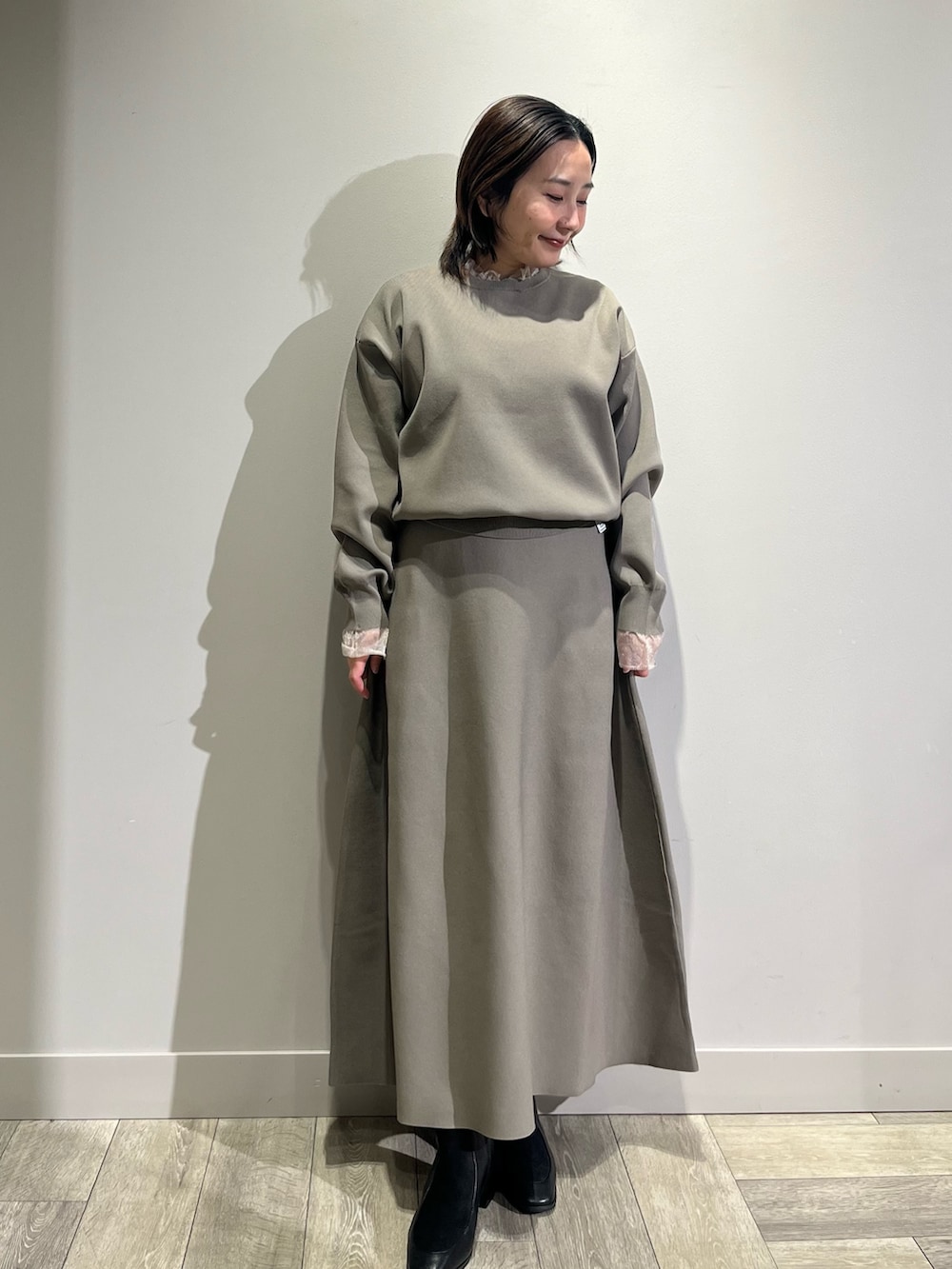 ベージュ系のワンピース、ブルー系のノーカラーコートを着用したレディースの冬コーディネートの2枚目の写真