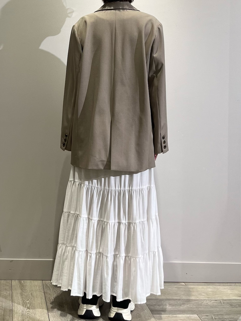 ベージュ系のテーラードジャケット、ホワイト系のスカート、ブラウン系のTシャツ/カットソーを着用したレディースの春コーディネートの4枚目の写真