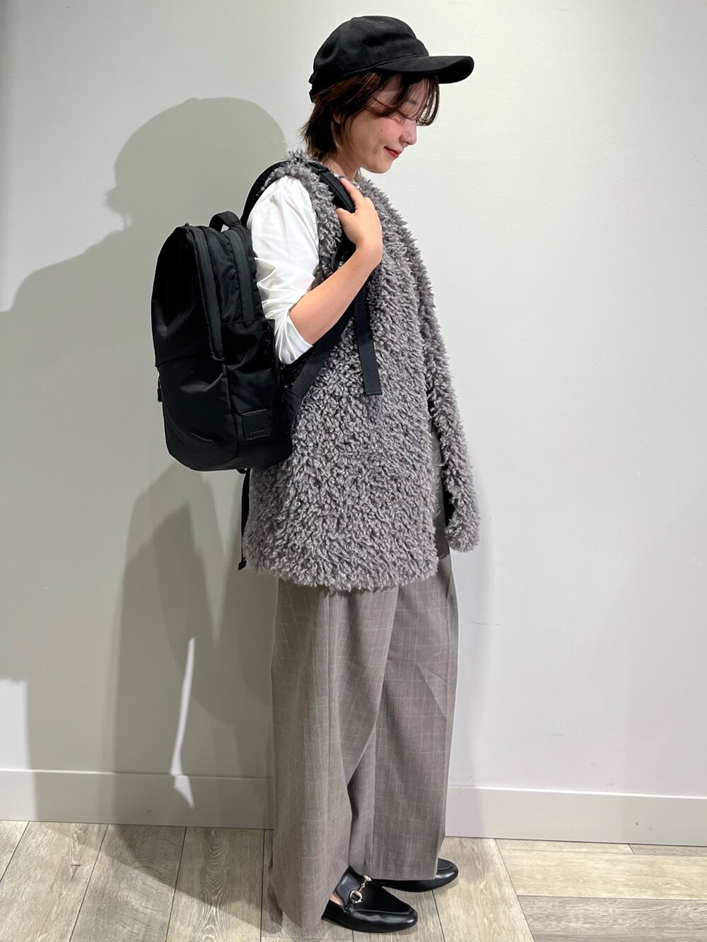 グレー系のベスト、ホワイト系のTシャツ/カットソー、ブラウン系のその他パンツを着用したレディースの秋コーディネートの2枚目の写真