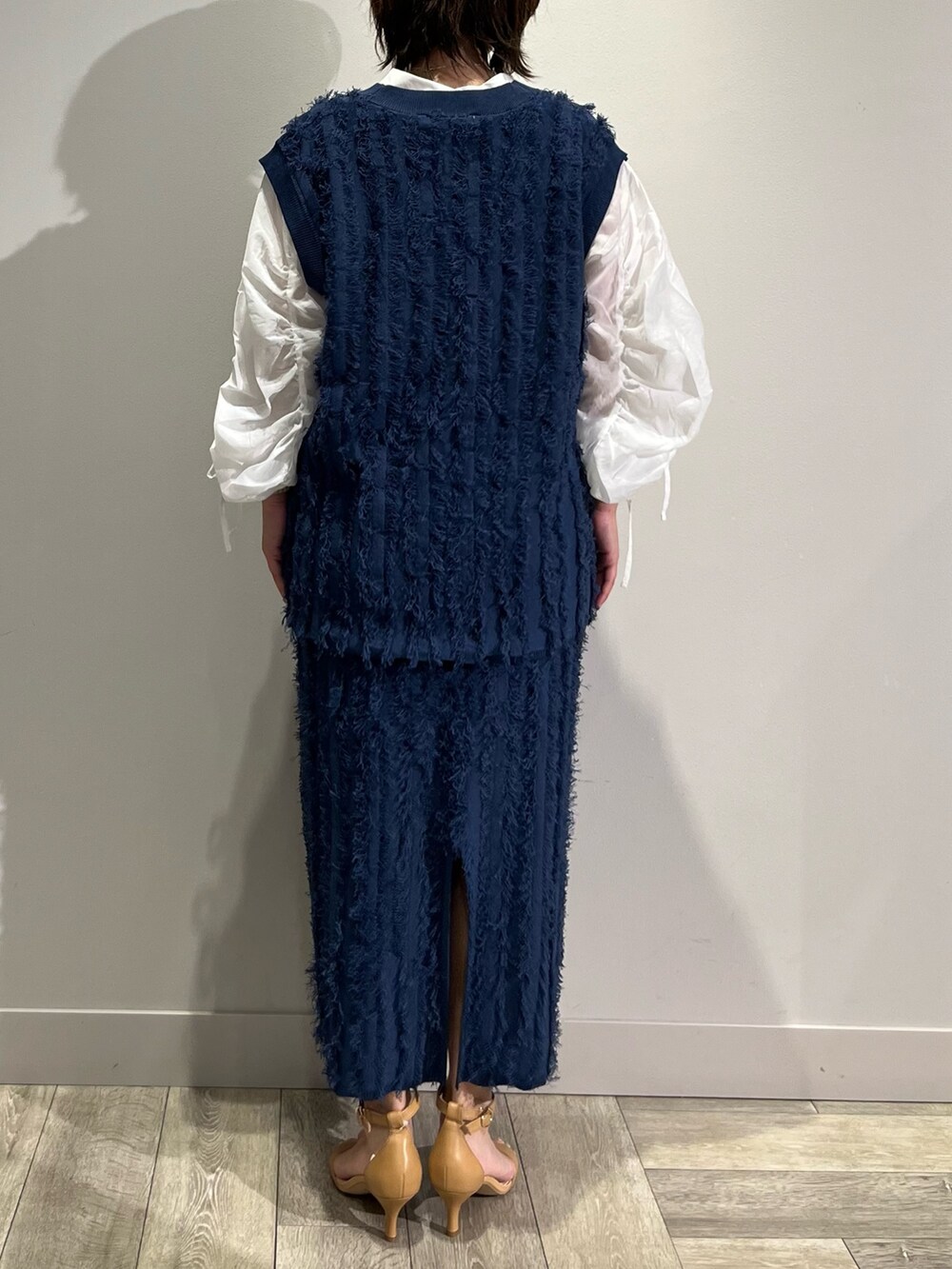 ブルー系のベスト、ブルー系のスカート、ホワイト系のシャツ/ブラウスを着用したレディースの秋コーディネートの3枚目の写真