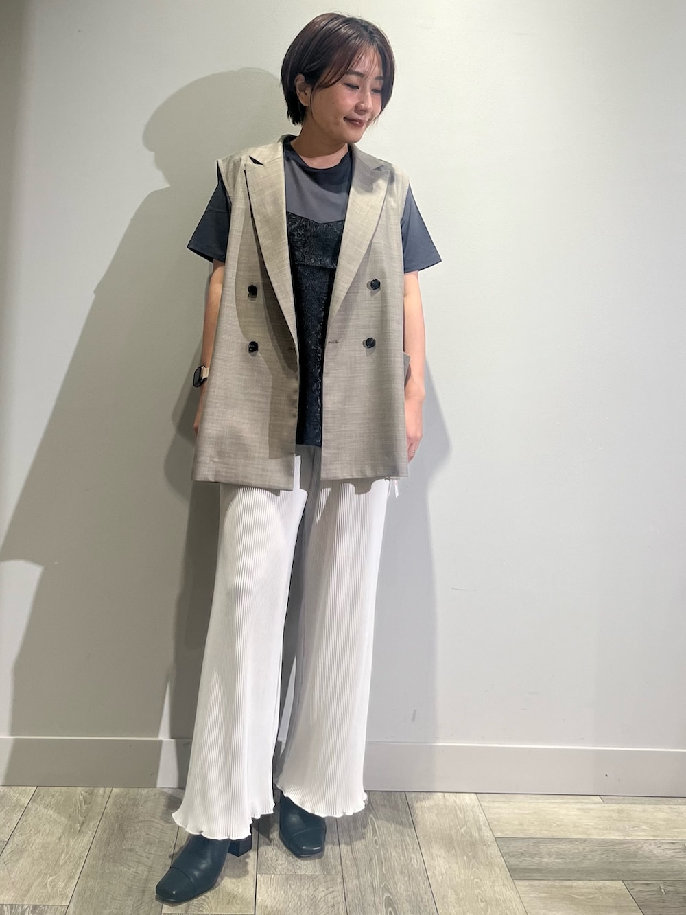 ホワイト系のその他パンツ、ブラウン系のベスト、ブラック系のTシャツ/カットソーを着用したレディースの夏コーディネートの2枚目の写真