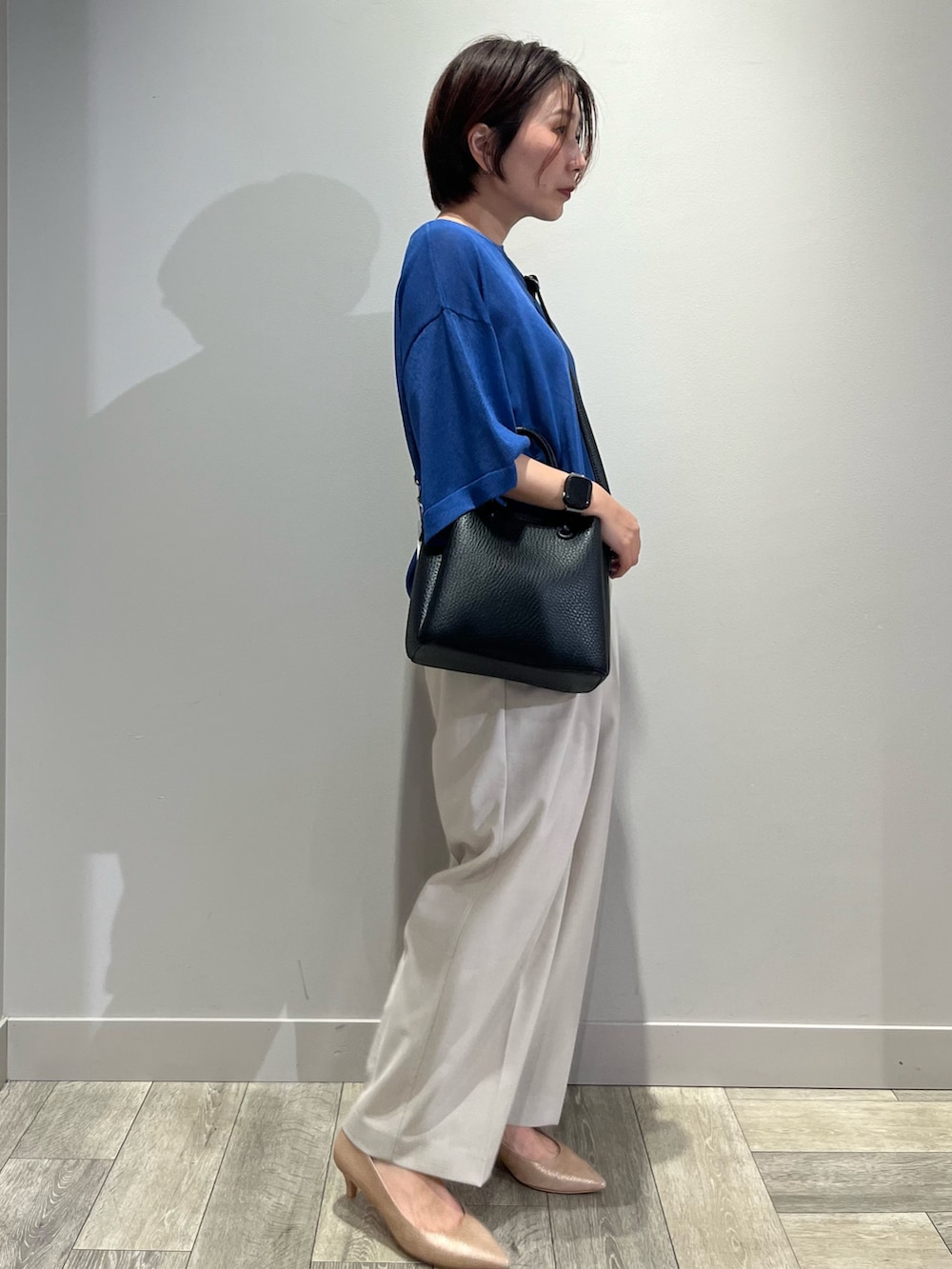ブルー系のニット/セーター、ベージュ系のその他パンツを着用したレディースの夏コーディネートの3枚目の写真