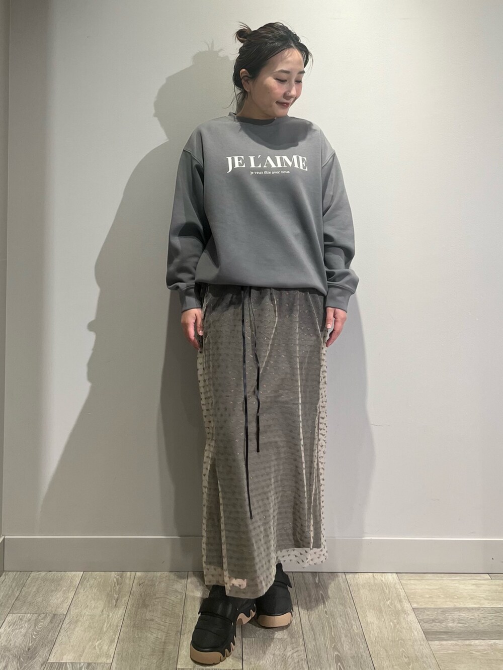 ブルー系のシャツ/ブラウス、ブラック系のスカート、ブラック系のスニーカーを着用したレディースの冬コーディネートの2枚目の写真