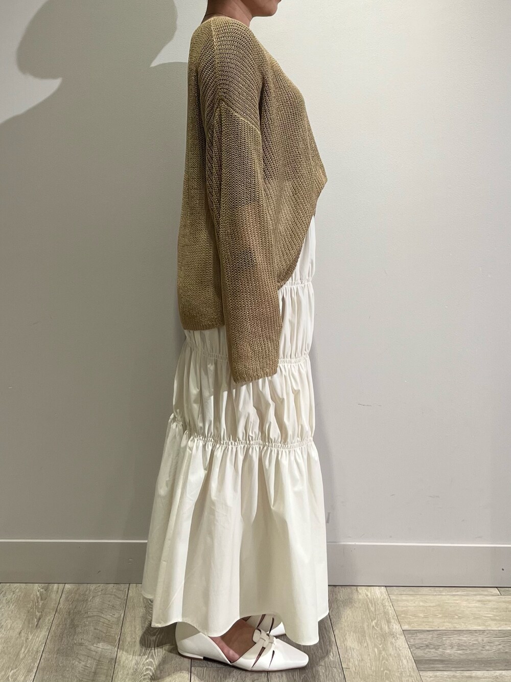 ベージュ系のニット/セーター、ホワイト系のスカート、グリーン系のブルゾンを着用したレディースの春コーディネートの3枚目の写真