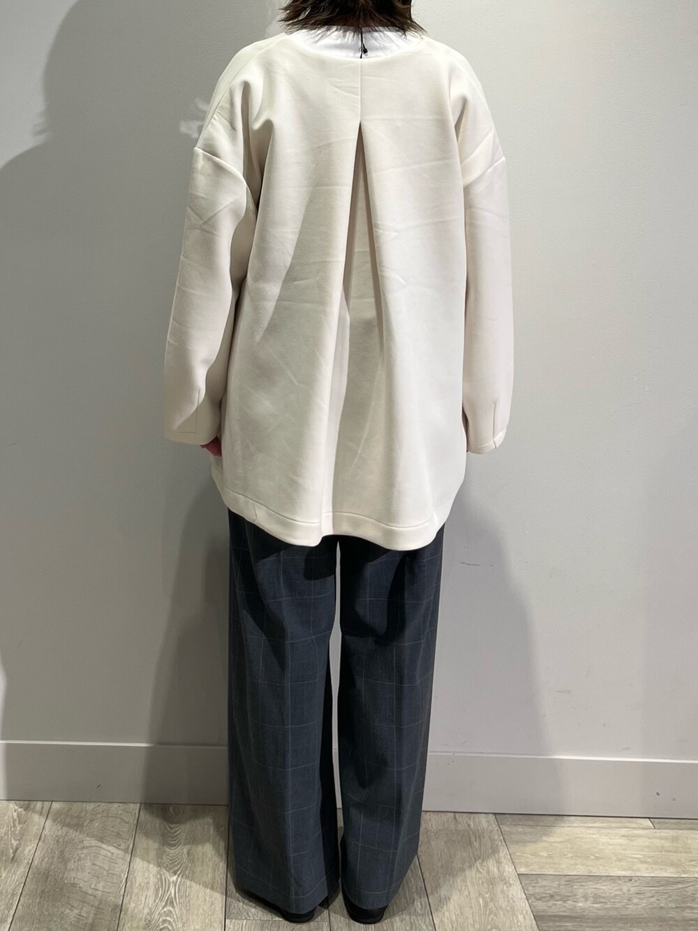 ホワイト系のノーカラーコート、グレー系のその他パンツ、ホワイト系のTシャツ/カットソーを着用したレディースの秋コーディネートの5枚目の写真