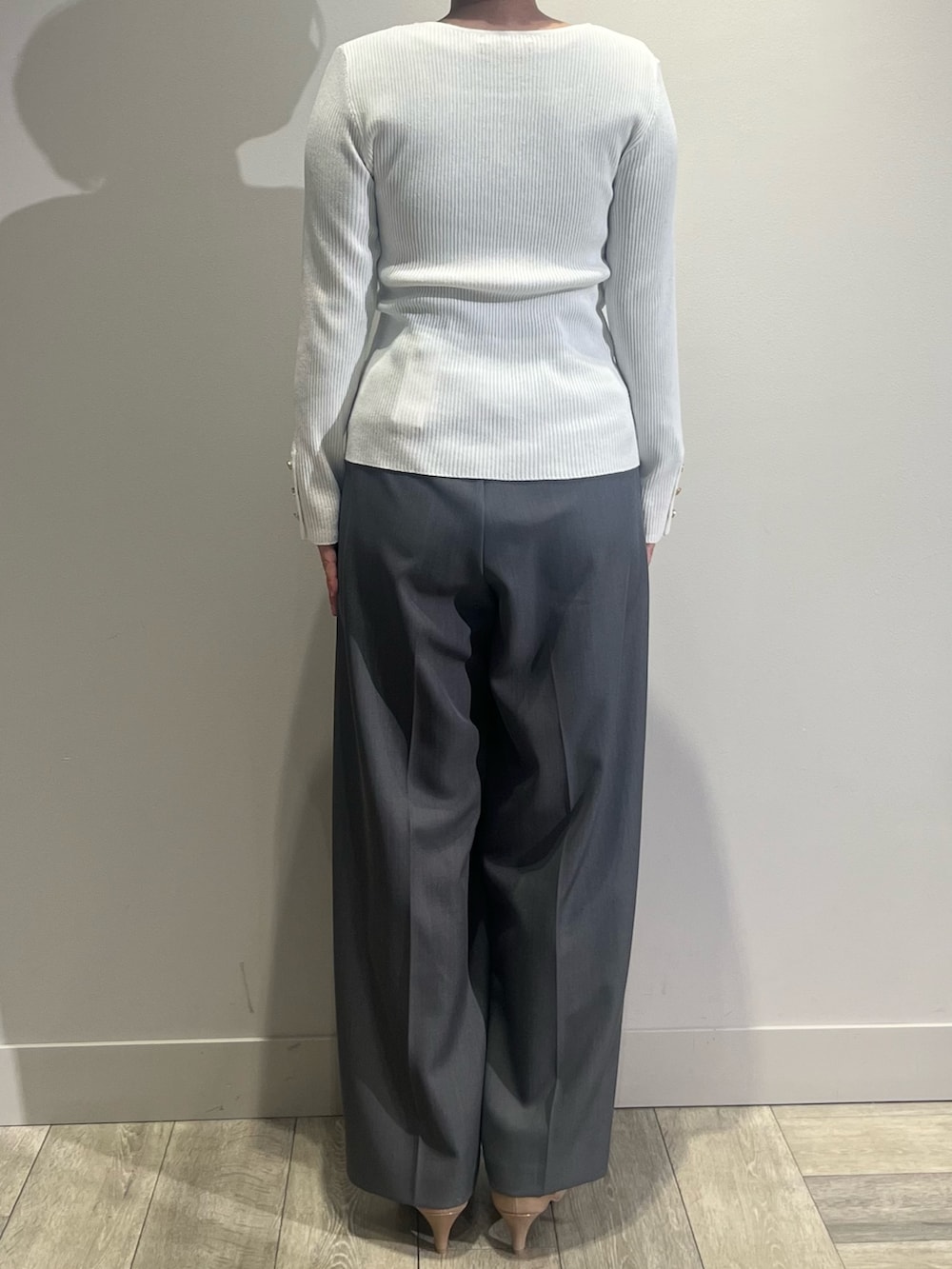 グレー系のテーラードジャケット、グレー系のスラックス、ホワイト系のニット/セーターを着用したレディースの冬コーディネートの4枚目の写真