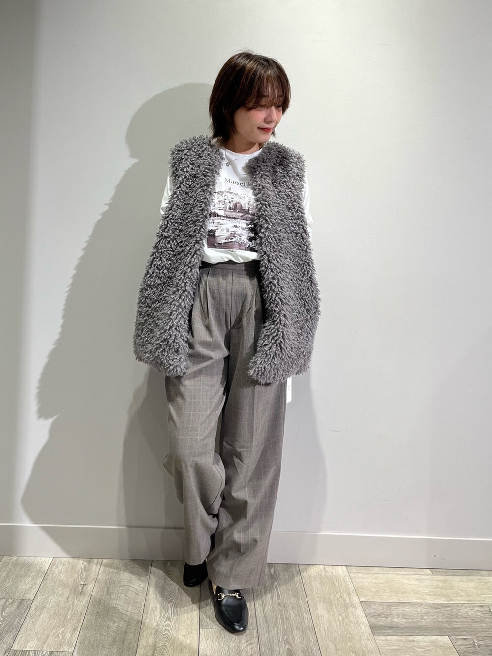 グレー系のベスト、ホワイト系のTシャツ/カットソー、ブラウン系のその他パンツを着用したレディースの秋コーディネートの5枚目の写真