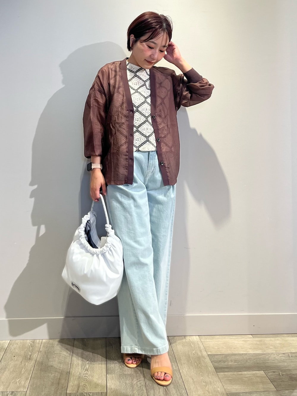 ブラウン系のカーディガン/ボレロ、ホワイト系のベスト、ブルー系のデニムパンツを着用したレディースの夏コーディネートの5枚目の写真