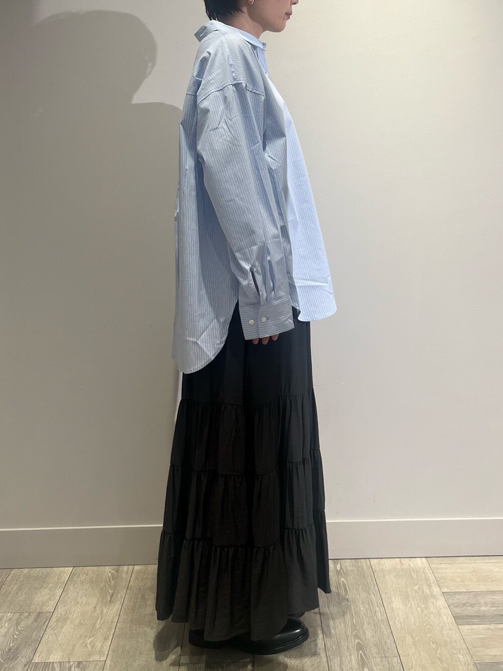 グレー系のテーラードジャケット、ホワイト系のニット/セーター、グレー系のスカートを着用したレディースの冬コーディネートの3枚目の写真