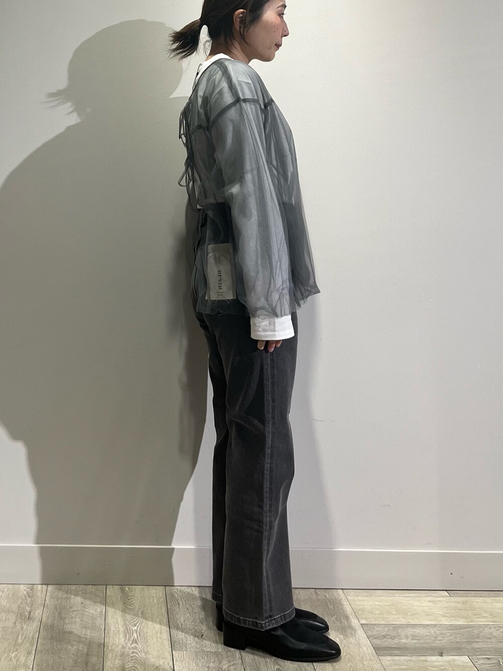 ホワイト系のカーディガン/ボレロ、グレー系のシャツ/ブラウス、ホワイト系のTシャツ/カットソーを着用したレディースの冬コーディネートの3枚目の写真
