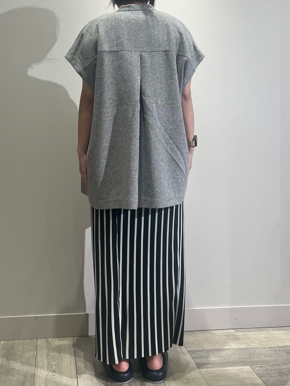 ブラウン系のかごバッグ、ベージュ系のノーカラージャケット、ホワイト系のTシャツ/カットソーを着用したレディースの春コーディネートの4枚目の写真