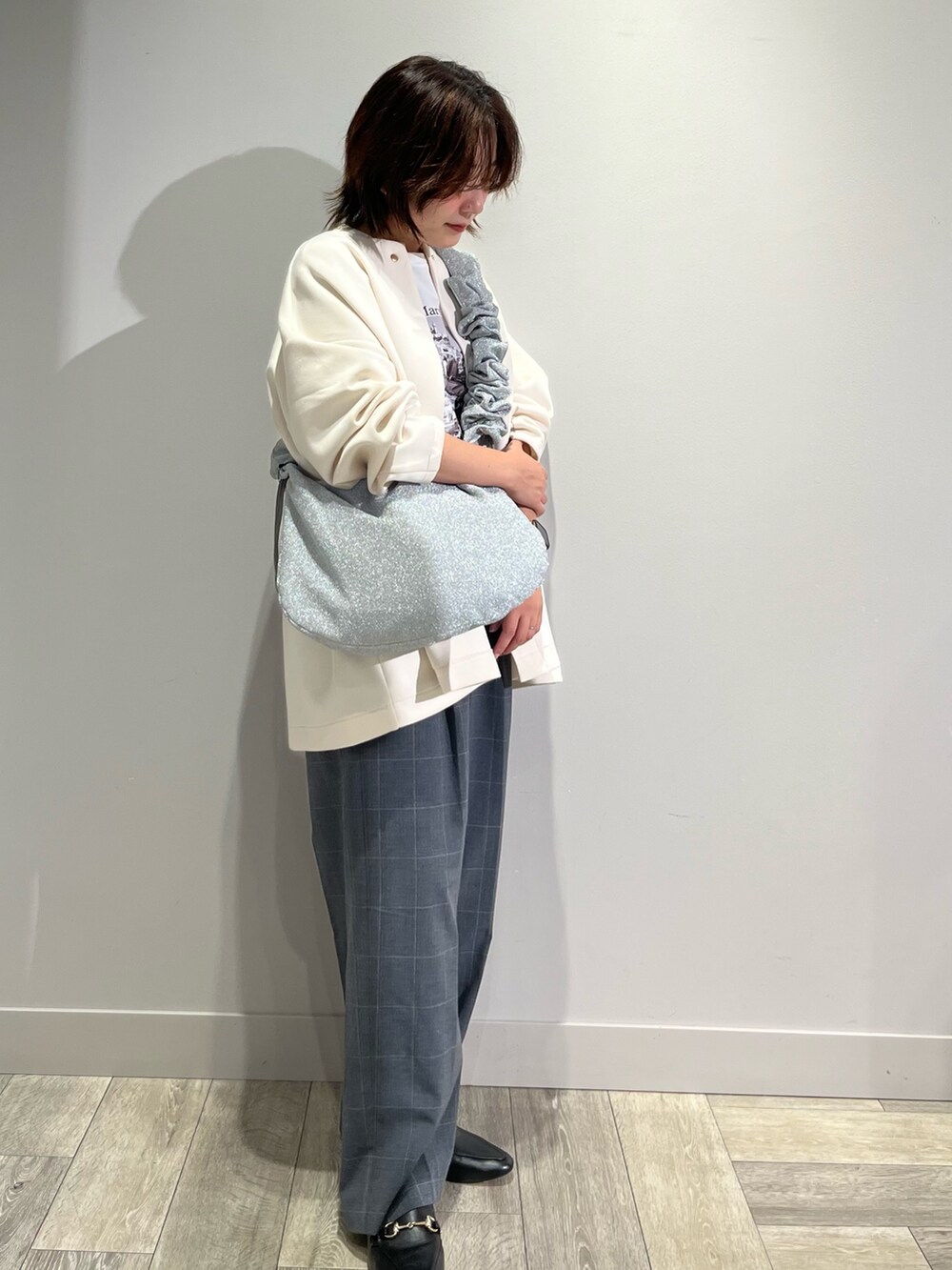 ホワイト系のノーカラーコート、グレー系のその他パンツ、ホワイト系のTシャツ/カットソーを着用したレディースの秋コーディネートの2枚目の写真