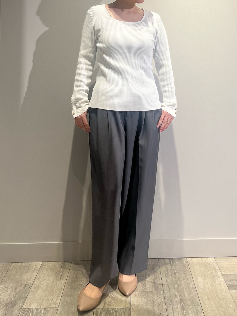 グレー系のテーラードジャケット、グレー系のスラックス、ホワイト系のニット/セーターを着用したレディースの冬コーディネートの2枚目の写真