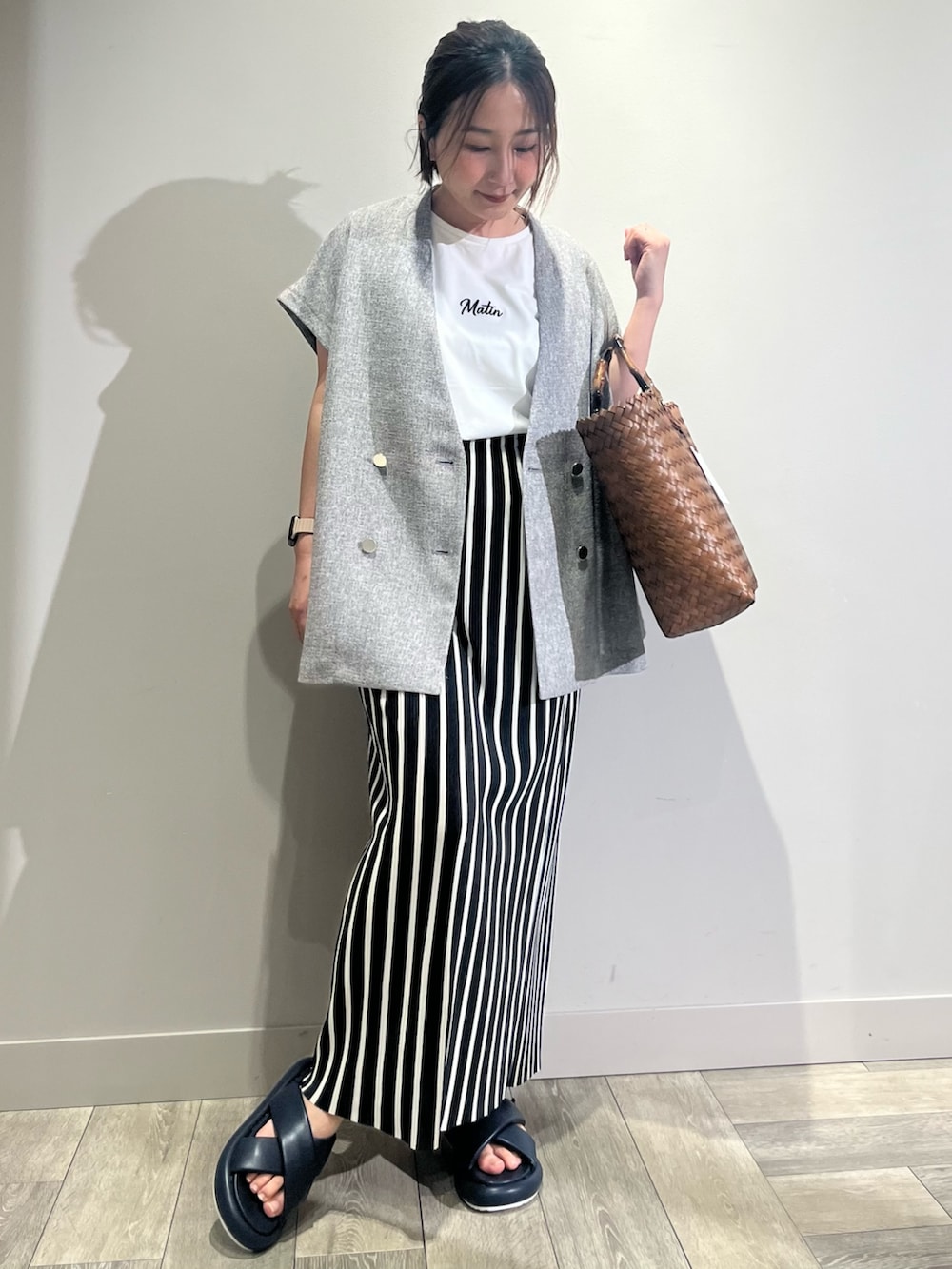 ブラウン系のかごバッグ、ベージュ系のノーカラージャケット、ホワイト系のTシャツ/カットソーを着用したレディースの春コーディネートの5枚目の写真