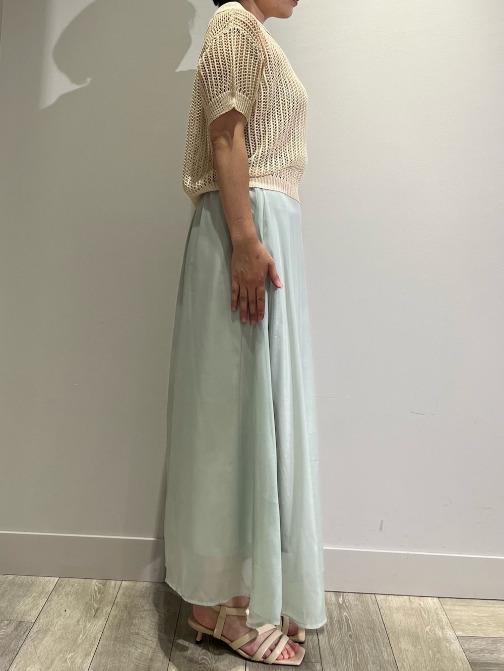 グリーン系のスカート、ベージュ系のニット/セーター、ベージュ系のサンダルを着用したレディースの夏コーディネートの3枚目の写真