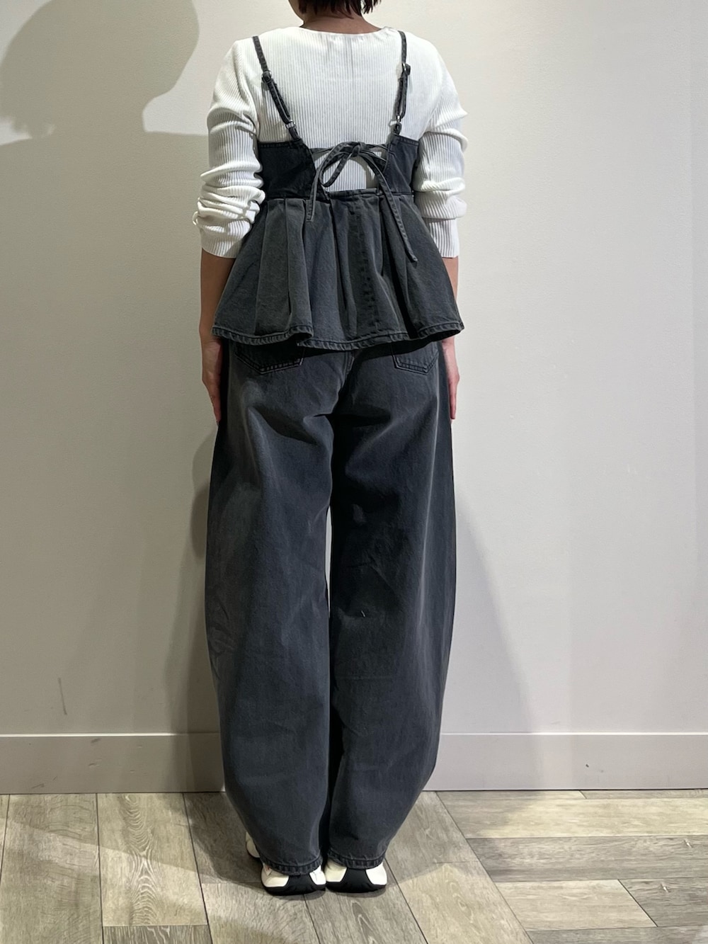 グレー系のキャミソール、グレー系のデニムパンツ、ホワイト系のニット/セーターを着用したレディースの春コーディネートの4枚目の写真