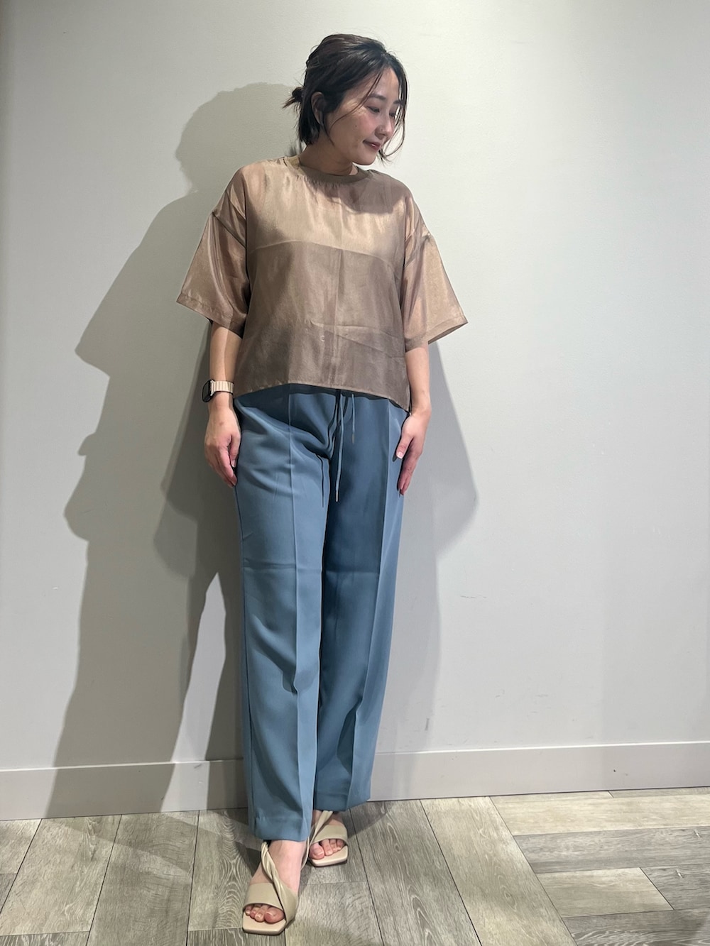 ブラウン系のシャツ/ブラウス、ホワイト系のタンクトップ、ブルー系のスラックスを着用したレディースの春コーディネートの2枚目の写真