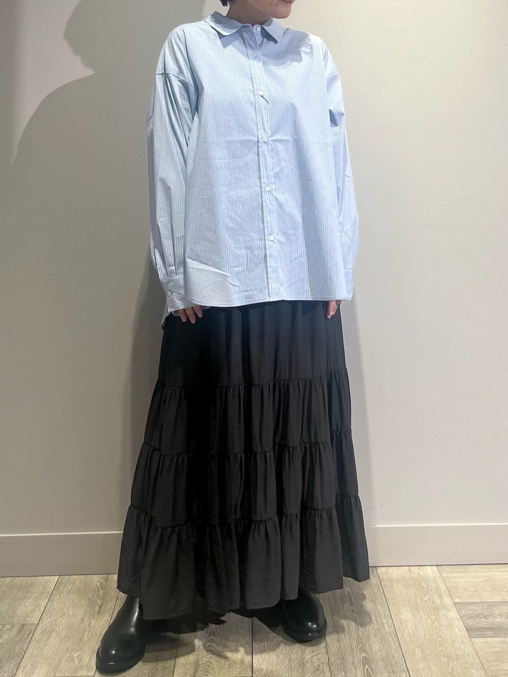 グレー系のテーラードジャケット、ホワイト系のニット/セーター、グレー系のスカートを着用したレディースの冬コーディネートの2枚目の写真