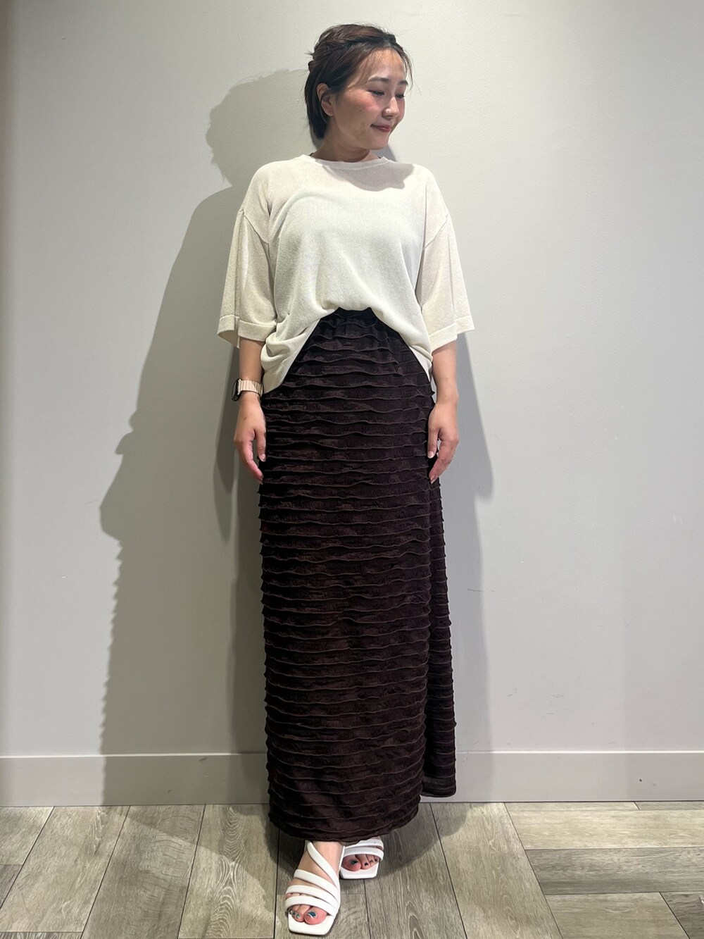 ホワイト系のニット/セーター、ブラウン系のスカートを着用したレディースの夏コーディネートの2枚目の写真